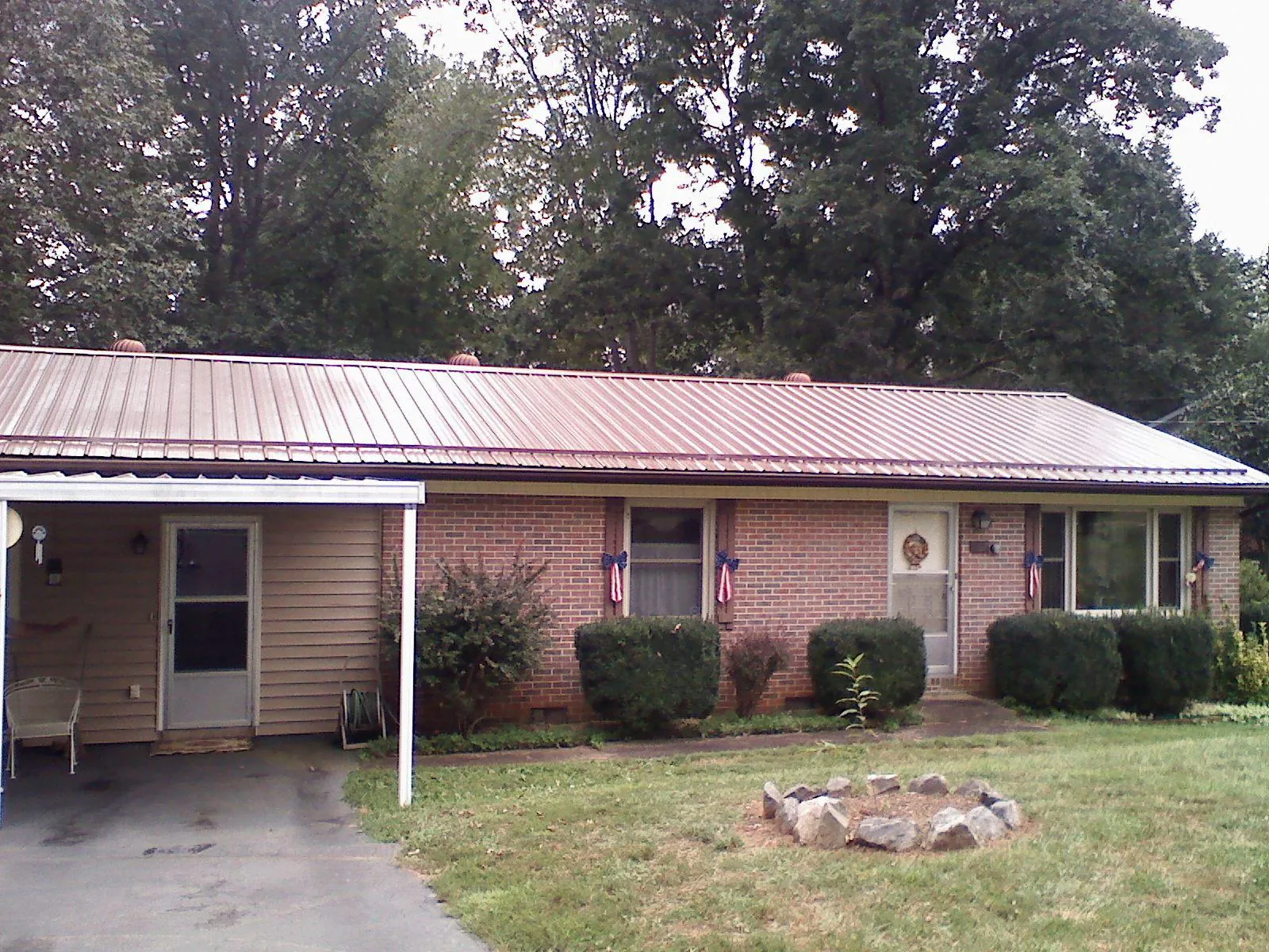 Bronze metal roof and carport on a brick ranch home — Roof Repair work by our crew in Applegate