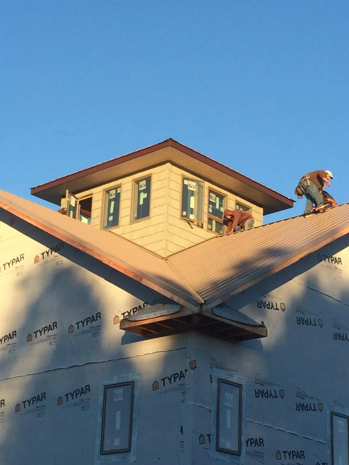 Roofers working around a rooftop cupola on a new metal roof at sunset — Roof Waterproofing in Applegate by Roofing Brothers